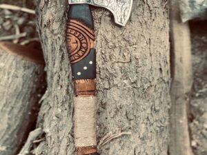 Close-up of man's hand gripping Viking Ragnar axe with leather-wrapped handle