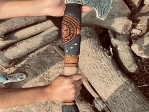 Man demonstrating Viking Ragnar axe with carbon steel blade and ash wood handle